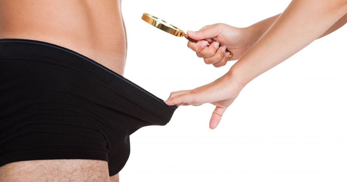 O fată se uită printr -o lupă la un mic penis